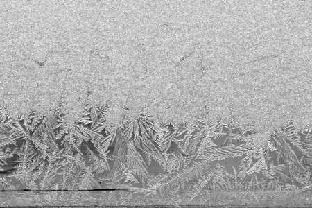 Frost on the window, Natural texture on glass with frozen pattern. Copy space, natural background, macro. Beautiful winter backgroundの写真素材