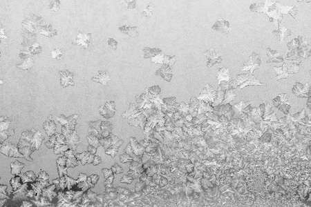 Frost on the window, Natural texture on glass with frozen pattern. Copy space, natural background, macro. Beautiful winter backgroundの写真素材