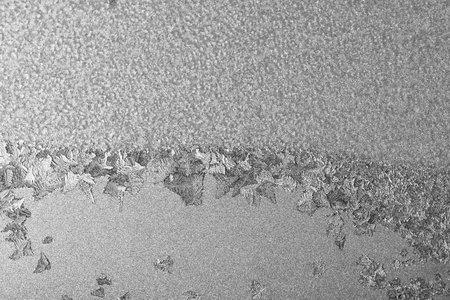 Frost on the window, Natural texture on glass with frozen pattern. Copy space, natural background, macro. Beautiful winter backgroundの写真素材
