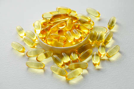 Biological and ecological CBD vegetable oil capsules on white background, Group of transparent CBD cannabidiol capsules. Medical cannabis productsの写真素材