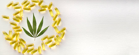Biological and ecological CBD vegetable oil capsules on white background, Group of transparent CBD cannabidiol capsules. Medical cannabis productsの写真素材