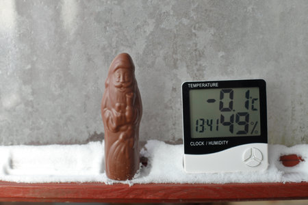 Humidity indicator is displayed on hygrometer installed in the snow next to the chocolate Santa Claus. Picture of an electronic device for testing air temperature and humidityの写真素材