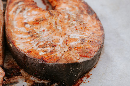 Red fried fish steaks. Baked salmon pieces. Juicy appetizing salmon lies on baking sheet. healthy food conceptの写真素材