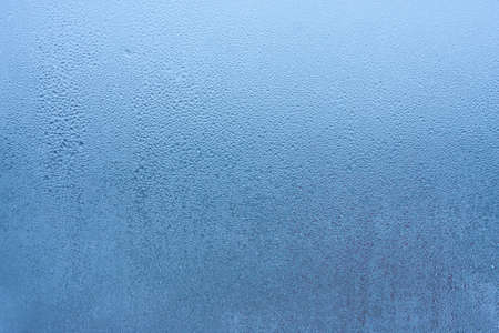 Water droplets condensation background of dew on glass, humidity and foggy blank background. Condensation on the glass of metal-plastic window. Outside the window, bad weather, rainの写真素材