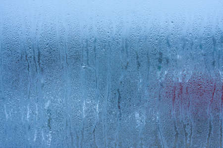 Water droplets condensation background of dew on glass, humidity and foggy blank background. Condensation on the glass of metal-plastic window. Outside the window, bad weather, rainの写真素材