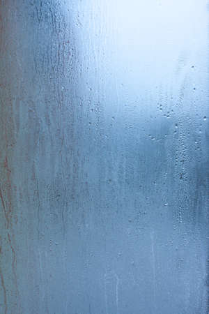 Water droplets condensation background of dew on glass, humidity and foggy blank background. Condensation on the glass of metal-plastic window. Outside the window, bad weather, rainの写真素材