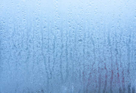 Background water drops on the glass, wet window glass with splashes and drops of water and lime, texture autumn background. Condensation on the glassの写真素材