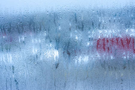 Water droplets condensation background of dew on glass, humidity and foggy blank background. Condensation on the glass of metal-plastic window. Outside the window, bad weather, rainの写真素材