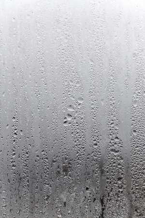 Water condensation on window glass background. Outside , bad weather, rain, humidity and foggy blank. vertical natural backgroundの写真素材