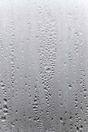 Water condensation on window glass background. Outside , bad weather, rain, humidity and foggy blank. vertical natural backgroundの写真素材