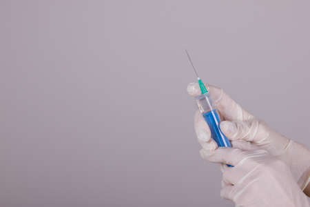 medical syringe and needle in hands in medical glovesの写真素材