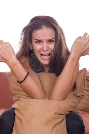 upset cute girl screaming and hugging pillowの写真素材