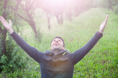 young man with open arms looking up