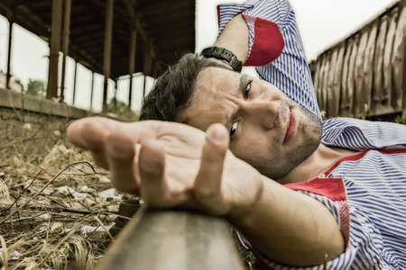 young man lying on the tracks and posingの写真素材