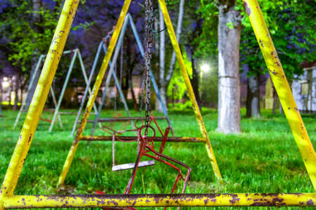 abandoned broken swings in the kids parkの写真素材