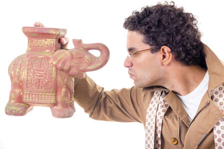 somber professor in coat with glasses and scarf looking old artifactの写真素材