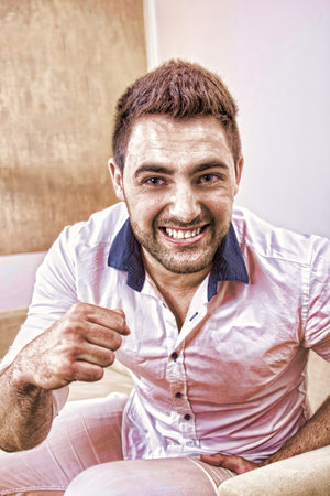 strong handsome man laughing and showing his fist