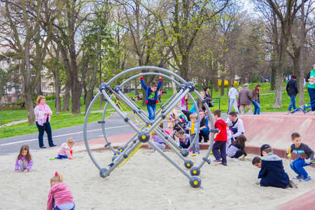 little children climb on the jungle gym in sand at the parkのeditorial素材