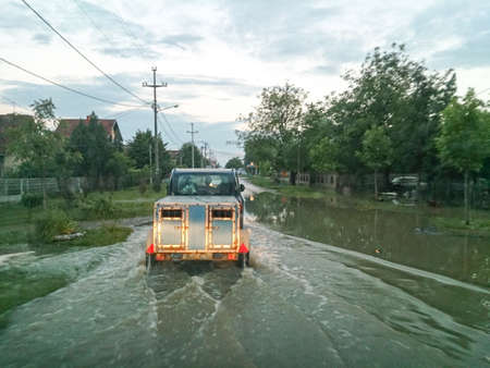 transport animals to safety through a flooded road with car, evacuate animals, flood and disaster in town Obrenovac in Serbia, damaged houses and property, state or condition after terrible flood, destroyed and abandoned cityの写真素材