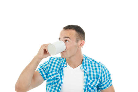 Young muscular guy drinking coffee or tea in the mug enjoying it, Coffee breakの写真素材
