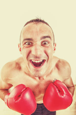 funny portrait of a confused and astonished man with red boxing gloves looking at cameraの写真素材