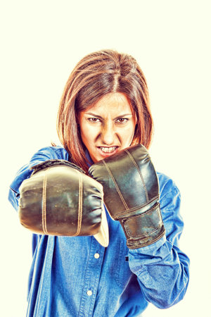 Angry businesswoman with boxing gloves posing, fight concept