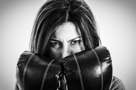 Closeup portrait of a determined female boxer. Confident, fearless and furious modern business woman...