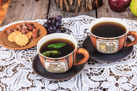 Traditional tea set with cookies and fruit on doily in vintage style