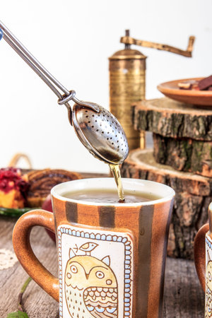 Tea strainer on vintage wooden table with homemade cookies and grinderの写真素材