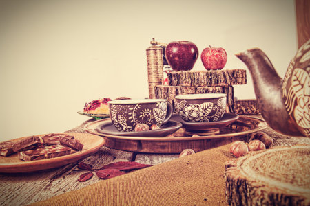Retro kitchen table in nostalgic still life style with tea set and kettle with chocolate and nuts asideの写真素材