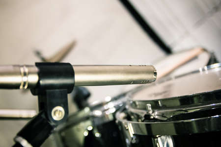 vintage retro professional microphone placed close to drums with sticks, preparation before recording in music studioの写真素材