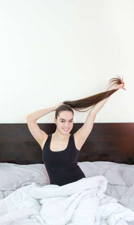  Beautiful woman or girl with long healthy black hair in bedの写真素材