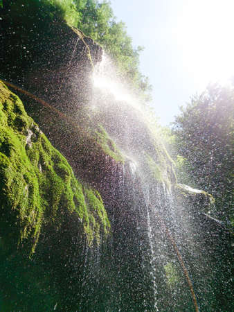 Close up of beautiful and fantastic waterfall in mountain in Romania nacional park. Closeup shot of fascinating waterfall water drops splashes to camera. Touch of forest magic by water in nature.の写真素材