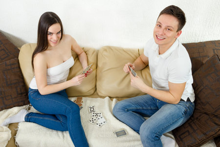 Young adult couple  relaxing and playing on blanket and pillows. Young adult couple wearing white...