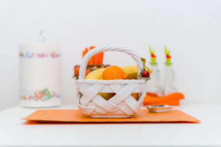 Interior of Small White Kitchen with Fresh Fruit Basket on the White Table. Bright Modern Kitchen...