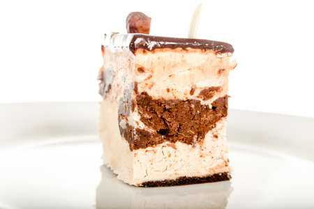 Chocolate Cheesecake Isolated on White Background. Dessert Piece of Cake on White Plate with Chocolate. Cake with Chocolate Cream Topping Isolated. Close-Up Image of Homemade Delicious Chocolate Cakeの写真素材