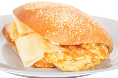Breakfast Sandwich with Bacon and Fried Scrambled Egg. Close Up of Toast with Hot Cheese and Poached...