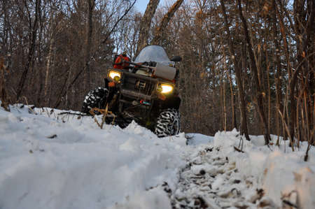An ATV on wheels stands on a taiga forest road in winterの写真素材