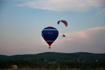 Balloon and paraglider in the evening sky.の写真素材