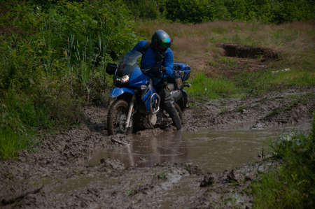Travelling on an enduro motorcycle in the taiga.の写真素材