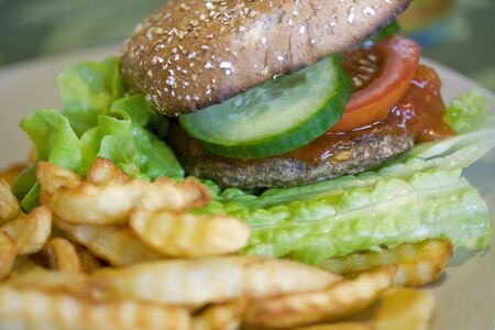 yummie burger and chips dinner with tomato, lettuce and cucumberの写真素材