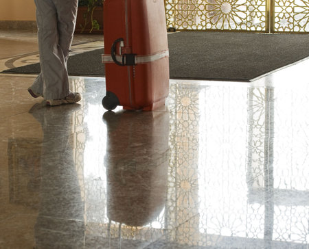 woman waiting in the lobby with her luggageの写真素材
