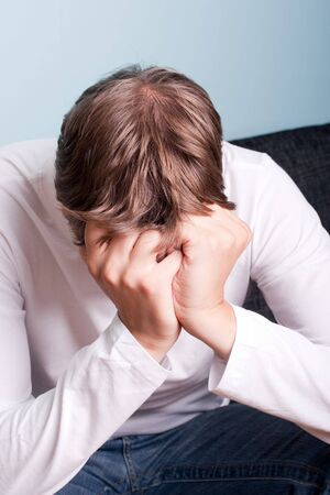 young man with his head in his handsの写真素材