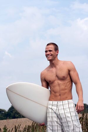 Surfer in checkered shorts on the way to the beachの写真素材