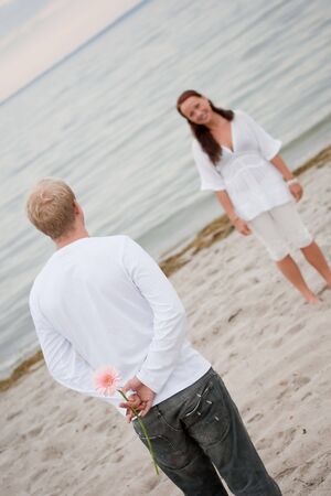 Young man giving flower to his girlfriendの写真素材
