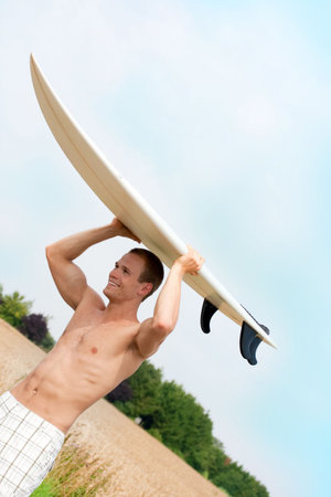 Handsome surfer on the way to the beach