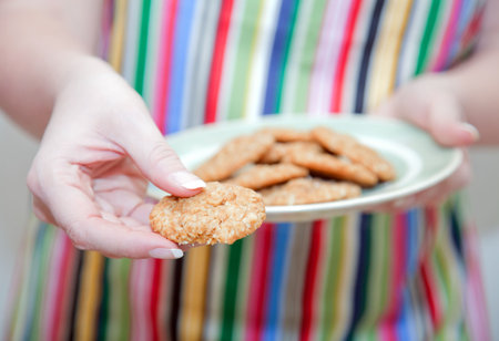Woman in stripy apron with cookiesの写真素材
