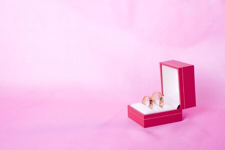 Gold wedding rings in a box on pink backgroundの写真素材