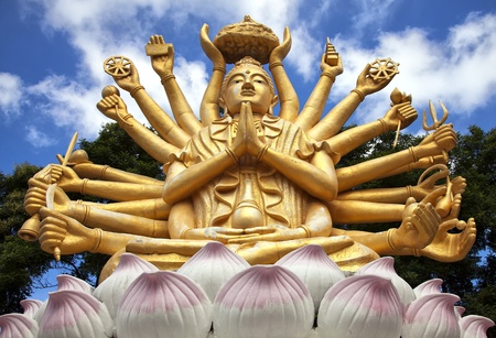 A huge statue of a multi armed buddha sits on a hill near to the city of Hua Hin in Thailand.の写真素材