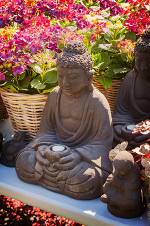 Image of decorative Buddha statues and flowering hydrangeas.の写真素材